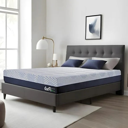 Durfi Hemp Hempseed Oil Mattress shown at an angle on a grey tufted bed frame in a bright contemporary bedroom with natural light and navy accent pillows