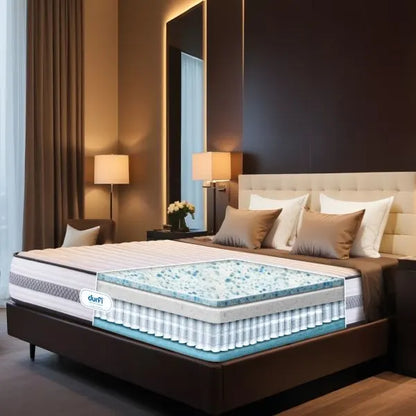 Cross-section view of Durfi Hybrid Pocket Spring Mattress on a hotel-style bed revealing the internal Cotton Candy Memory Foam layer in a warm luxury bedroom setting