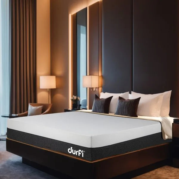Durfi Natural Latex Ortho Mattress displayed on a dark luxury bed frame in an upscale hotel-style bedroom with warm ambient lighting and decorative pillows