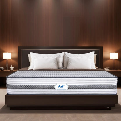 Durfi Ortho Memory Foam Mattress placed on a dark wood bed frame in a luxurious hotel-style bedroom with warm lighting and white pillows