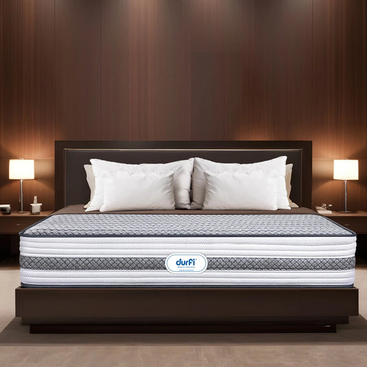 Durfi Ortho Memory Foam Mattress placed on a dark wood bed frame in a luxurious hotel-style bedroom with warm lighting and white pillows